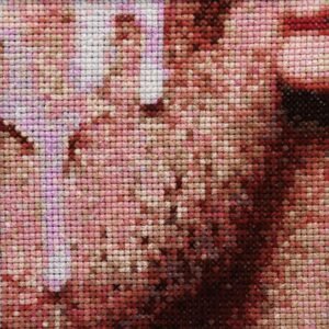 Leche — original 4×4 inch hand-stitched cross-stitch, an extreme close-up of a man's face and neck in warm blush pink, dusty rose, terracotta, burgundy, and soft lavender tones