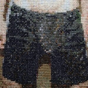 VPL — original 4×4 inch hand-stitched cross-stitch, a close-up crop of a man in dark navy and charcoal underwear against warm sand and blush skin tones on Aida cloth